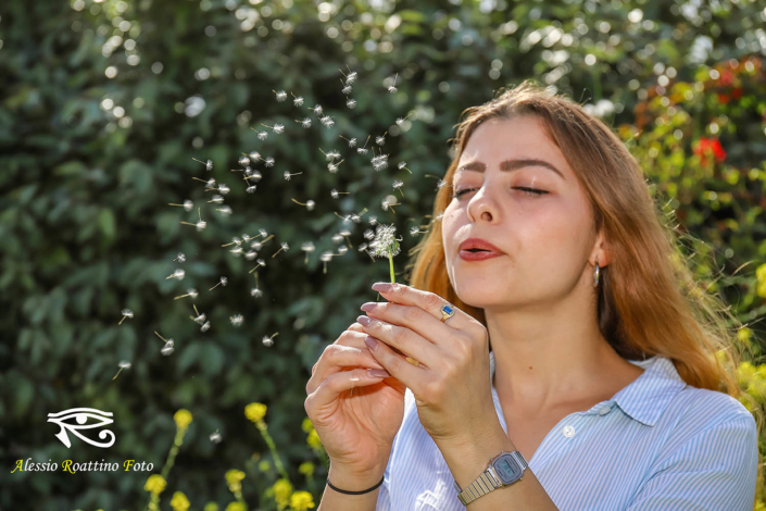 Adriana, ragazza bionda ripresa mentre soffia su un soffione